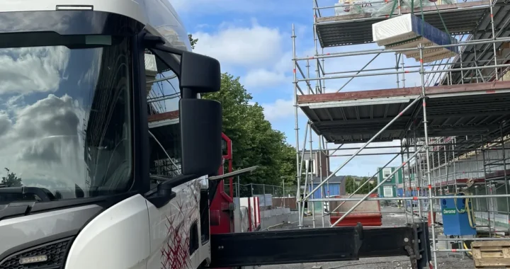 Kranbil som lyfter material på en byggarbetsplats